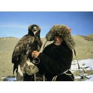 Kazakh Eagle Hunter Poses with His Eagle on a Plain in Kazakhstan 